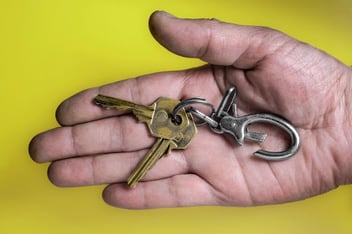hand with company keys and yellow background 
