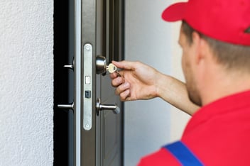 locksmith inserting key into door lock