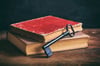 Image of an old iron key without IC core resting against vintage books